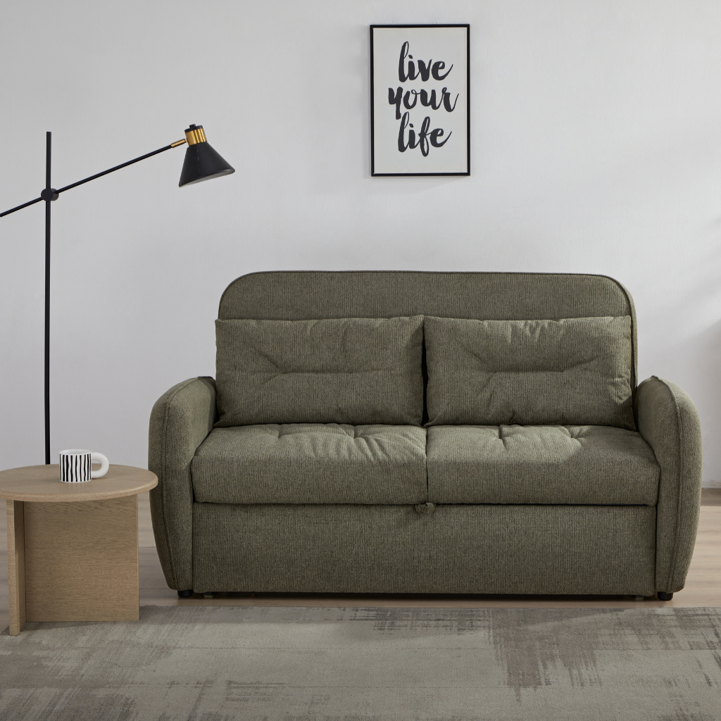 Enzo Sofa Bed Earthy Green showing compact 2-seater olive green fabric sofa styled with a modern floor lamp at NZ Furniture Warehouse
